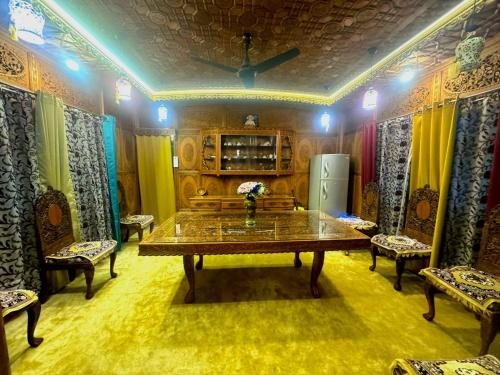 Camera con tavolo, sedie e frigorifero. di SoloSync - Hostel on the Boat a Srinagar