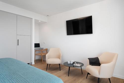 a bedroom with two chairs and a tv and a table at Repic Apartments Soller in Port de Soller