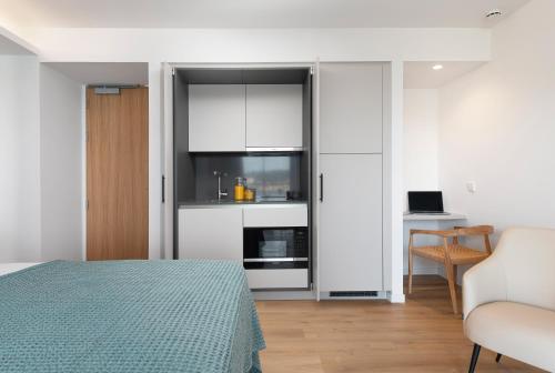 a room with a bed and a kitchen with white cabinets at Repic Apartments Soller in Port de Soller