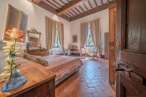 a bedroom with a bed and a table with a vase on it at Tenuta di Poggio Cavallo in Istia dʼOmbrone