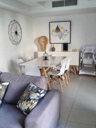 un salon avec un canapé, une table et des chaises dans l'établissement MAGNIFIQUE APPARTEMENT LES PIEDS DANS L'EAU PROPRIANO, à Propriano