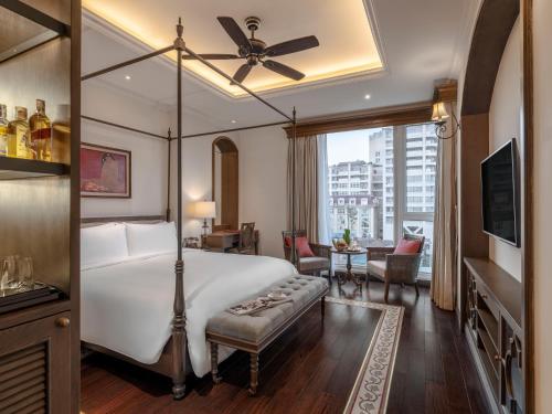 a bedroom with a bed and a living room at De Syloia Hotel in Hanoi