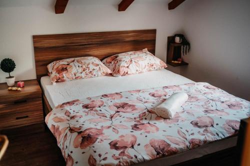 a bedroom with a bed with pink flowers on it at Kuća za odmor Mihaela in Široki Brijeg
