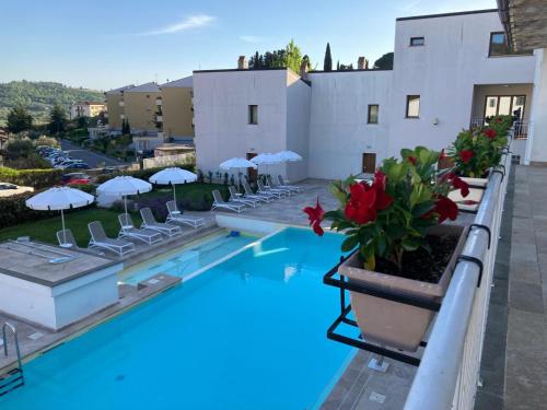 a hotel swimming pool with chairs and umbrellas at The Florence Hills Resort & Wellness in Pelago