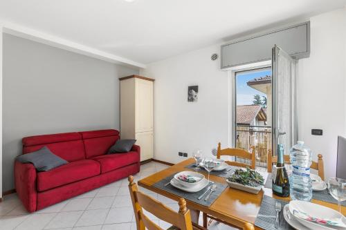 een woonkamer met een rode bank en een tafel bij Casa Elena - Happy Rentals in Riva del Garda