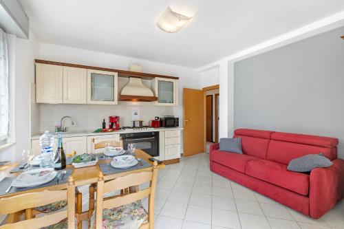 een woonkamer met een rode bank en een tafel bij Casa Elena - Happy Rentals in Riva del Garda