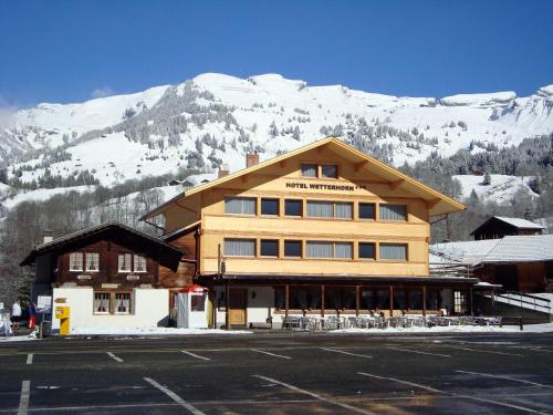 a large building with a snow covered mountain in the background at Hotel Wetterhorn in Grindelwald