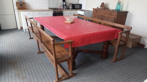 una mesa de cocina con un mantel rojo. en Gite du Manoir des Anoteux en Carneville