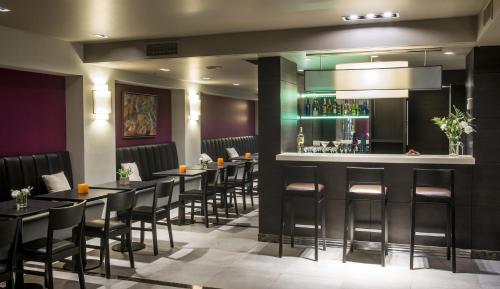 a bar in a restaurant with black tables and stools at ARC Recoleta Boutique Hotel & Spa in Buenos Aires