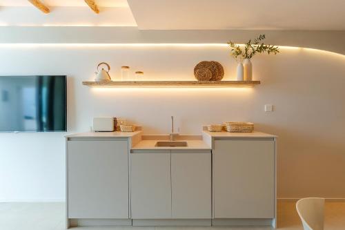 a kitchen with white cabinets and a sink at Apartamentos Azul in Castelldefels