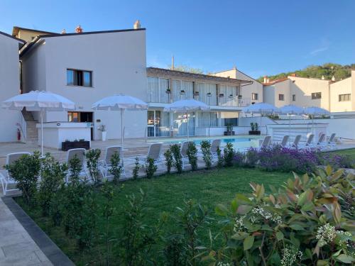 a resort with a pool and chairs and umbrellas at The Florence Hills Resort & Wellness in Pelago