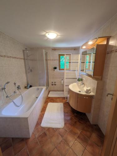 a bathroom with a tub and a shower and a sink at Ferienwohnung Elisabeth in Bischofswiesen