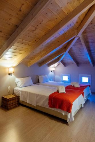 a bedroom with a large bed in a attic at Apelon Tiritas Villas in Leonidion