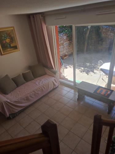 un salon avec un canapé et une porte coulissante en verre dans l'établissement Villa plein soleil, à Valbonne
