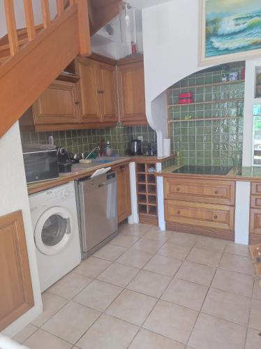 une cuisine avec une machine à laver et un lave-vaisselle dans l'établissement Villa plein soleil, à Valbonne