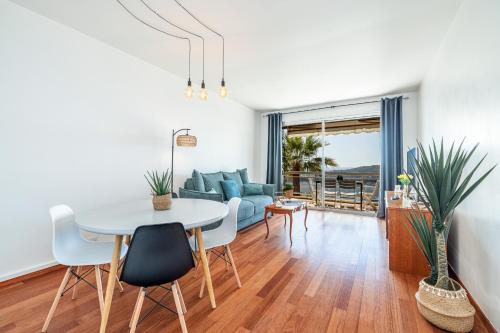 un salon avec une table et un canapé dans l'établissement Extraordinary Sea View - 1 Bdr with AC, à Villefranche-sur-Mer