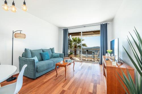 un salon avec un canapé bleu et une table dans l'établissement Extraordinary Sea View - 1 Bdr with AC, à Villefranche-sur-Mer