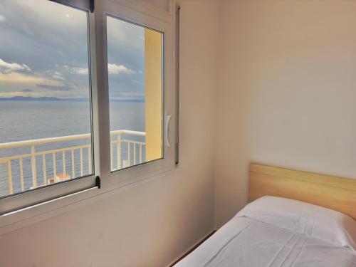 1 dormitorio con ventana y vistas al océano en Marina 4, en Roses