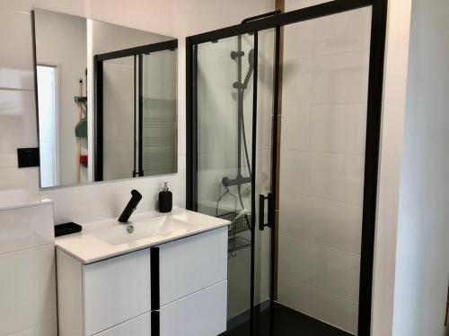 une salle de bain blanche avec un lavabo et une douche dans l'établissement Loft d'Architecte - Chic et Moderne, à Nantes