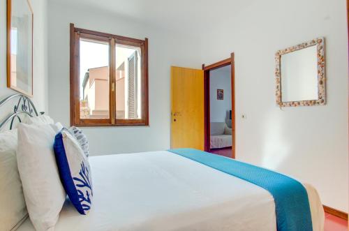 a white bedroom with a bed with blue and white pillows at PALAU APARTMENT - HOME and MORE in Palau