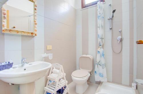 a white bathroom with a sink and a toilet at PALAU APARTMENT - HOME and MORE in Palau