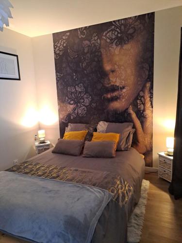 un dormitorio con una gran pintura de una mujer en Gîtes Les Lucioles en Mont-Saint-Aignan
