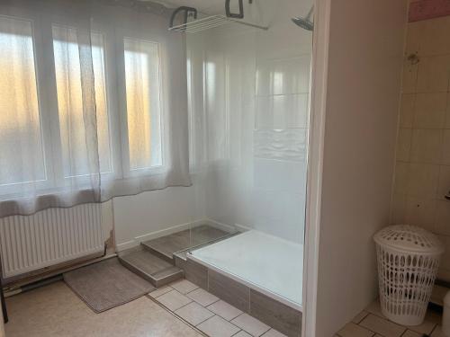 La salle de bains blanche est pourvue d'une baignoire et d'une fenêtre. dans l'établissement Maison proche centre ville Charleville-Mézières, à Charleville-Mézières