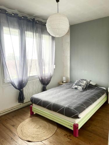 - une chambre avec un grand lit en face d'une fenêtre dans l'établissement Maison proche centre ville Charleville-Mézières, à Charleville-Mézières