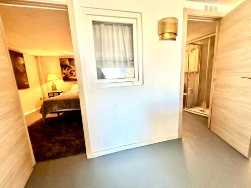 einen Flur mit einem Zimmer mit einem Bett und einem Fenster in der Unterkunft Aya House in Barcelona
