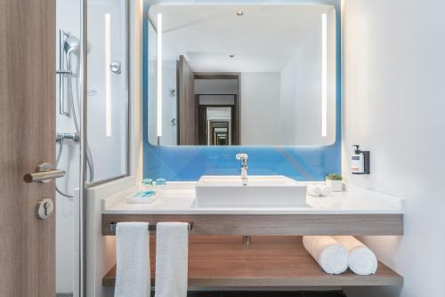 un baño con lavabo y espejo en Holiday Inn Express Guangzhou Panyu Dashi by IHG-Free Shuttle Bus to Canton Fair complex during Canton Fair Phase 1 & 2, en Guangzhou
