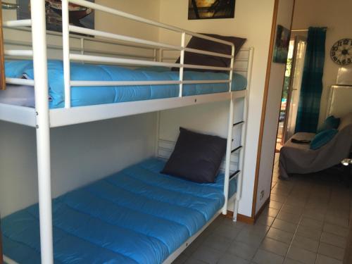 Cette chambre comprend 2 lits superposés dotés d'un oreiller bleu. dans l'établissement maisonnette saint georges de didonne, à Saint-Georges-de-Didonne