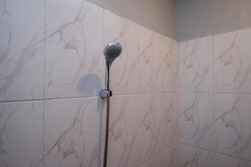 a shower with a shower head in a bathroom at RedDoorz Near Dr Oen Solo Baru Hospital in Klaten