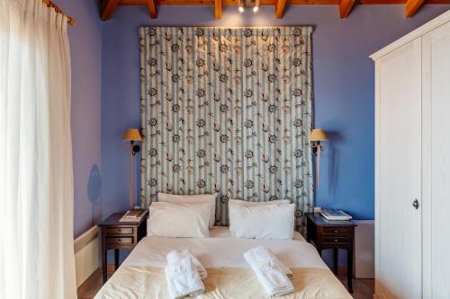 a bedroom with a bed with blue walls and a curtain at Apelon Tiritas Villas in Leonidion