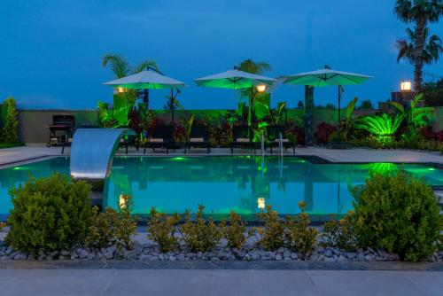 a pool with chairs and umbrellas at night at Edem Villa Diamond in Kemer