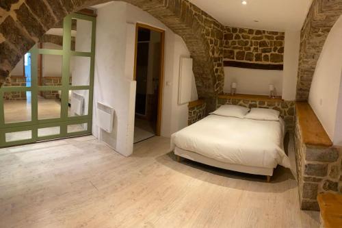 a bedroom with a bed and a stone wall at Appartement centre ville en RDC in Lorgues