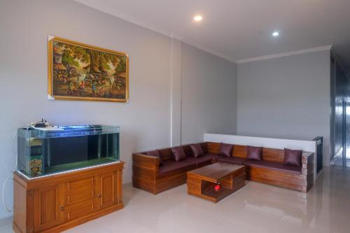 a living room with a couch and a fish tank at RedDoorz Near Dr Oen Solo Baru Hospital in Klaten