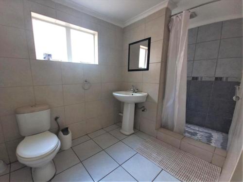 Johannesburg Airport Hostel في بينوني: حمام مع مرحاض ومغسلة