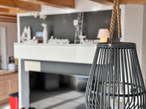 a hanging bird cage in front of a desk at Casa Via Bodman-Ludwigshafen in Bodman-Ludwigshafen