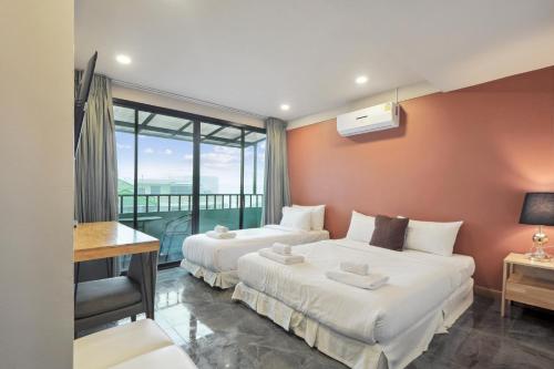 a hotel room with two beds and a balcony at Ployburi Boutique Hotel in Chanthaburi