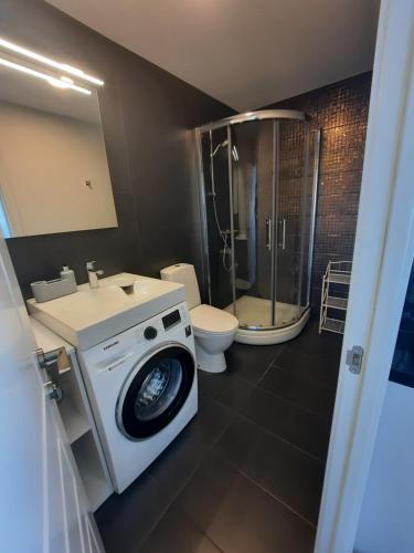 a bathroom with a washing machine and a toilet at Klaipėda city panoramic view in Klaipėda