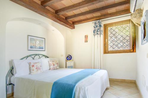 a bedroom with a bed in a room with a window at VILLA MARIA - CAPO D'ORSO - HOME and MORE in Palau