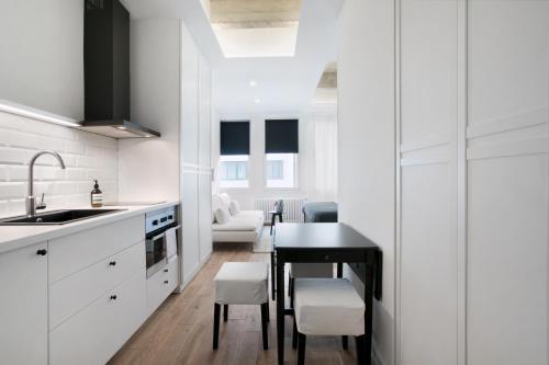 a kitchen with white cabinets and a black table at Angel Main Square Center Zagreb in Zagreb