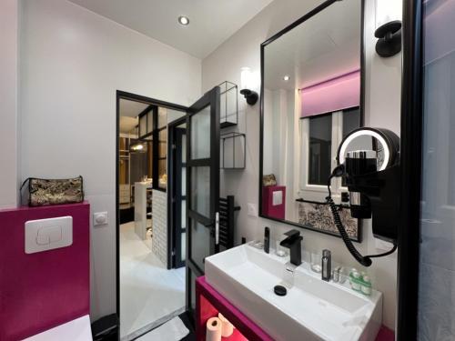 une salle de bain avec un lavabo et un miroir dans l'établissement Appartement design Paris 13eme, à Paris
