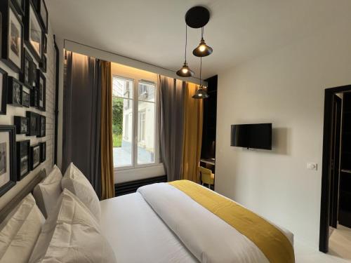 une chambre avec un lit blanc et une fenêtre dans l'établissement Appartement design Paris 13eme, à Paris