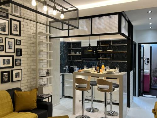 une cuisine avec un bar et des tabourets dans l'établissement Appartement design Paris 13eme, à Paris