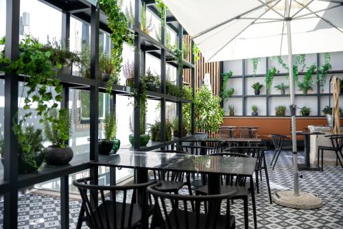 a restaurant with tables and chairs and plants at Villa Graça -Hostels and Apartments in Santarém