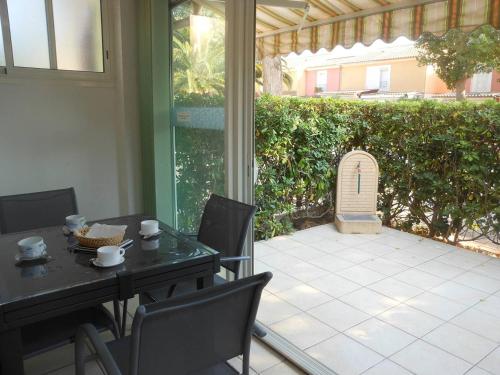 - une terrasse couverte avec une table et des chaises dans l'établissement APPT 3 PIECES 37m2 ET TERRASSE 11m2 REF 4055, à Le Castellas