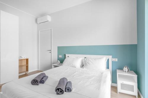 Un dormitorio con una cama blanca con zapatillas. en SIL5 - Apartment Bright - Luxury en Milán