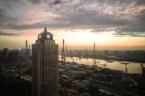 a clock tower on top of a building in a city at Sheraton Shanghai Pudong Riverside in Shanghai