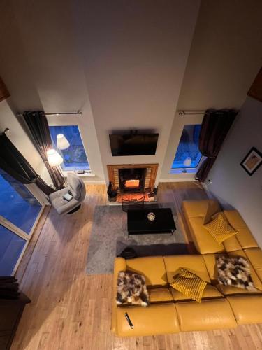 - un salon avec un canapé jaune dans l'établissement Spectacular Ocean Views in Tranquil and Private Location, à Dooagh